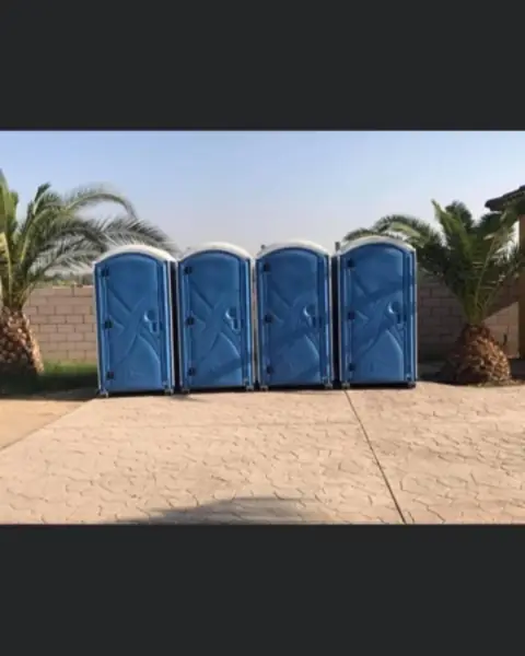 Four blue portable toilets lined up and ready to load
