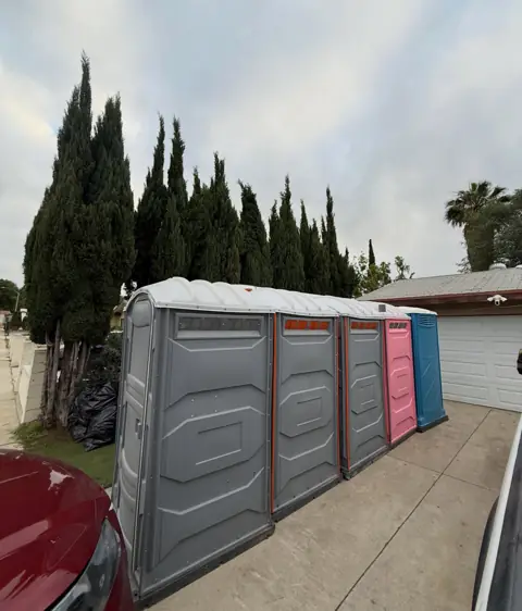 A row of portable toilets along the edge of a lot