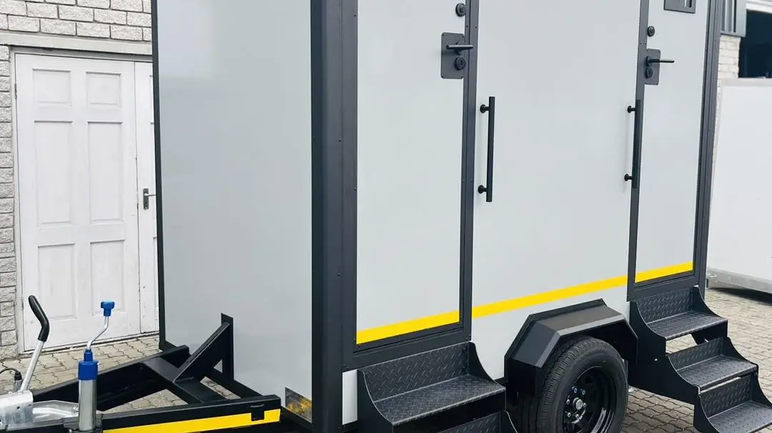 Two-door restroom trailer with fold-down steps