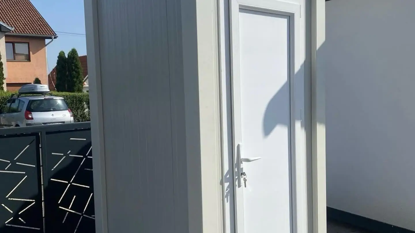 Restroom unit set in a home driveway during repairs
