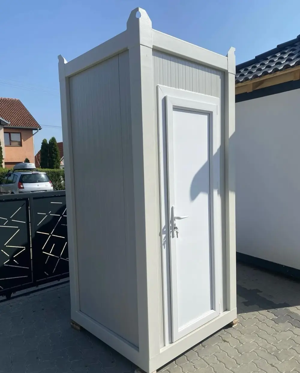 White flushing restroom cabin in a home driveway